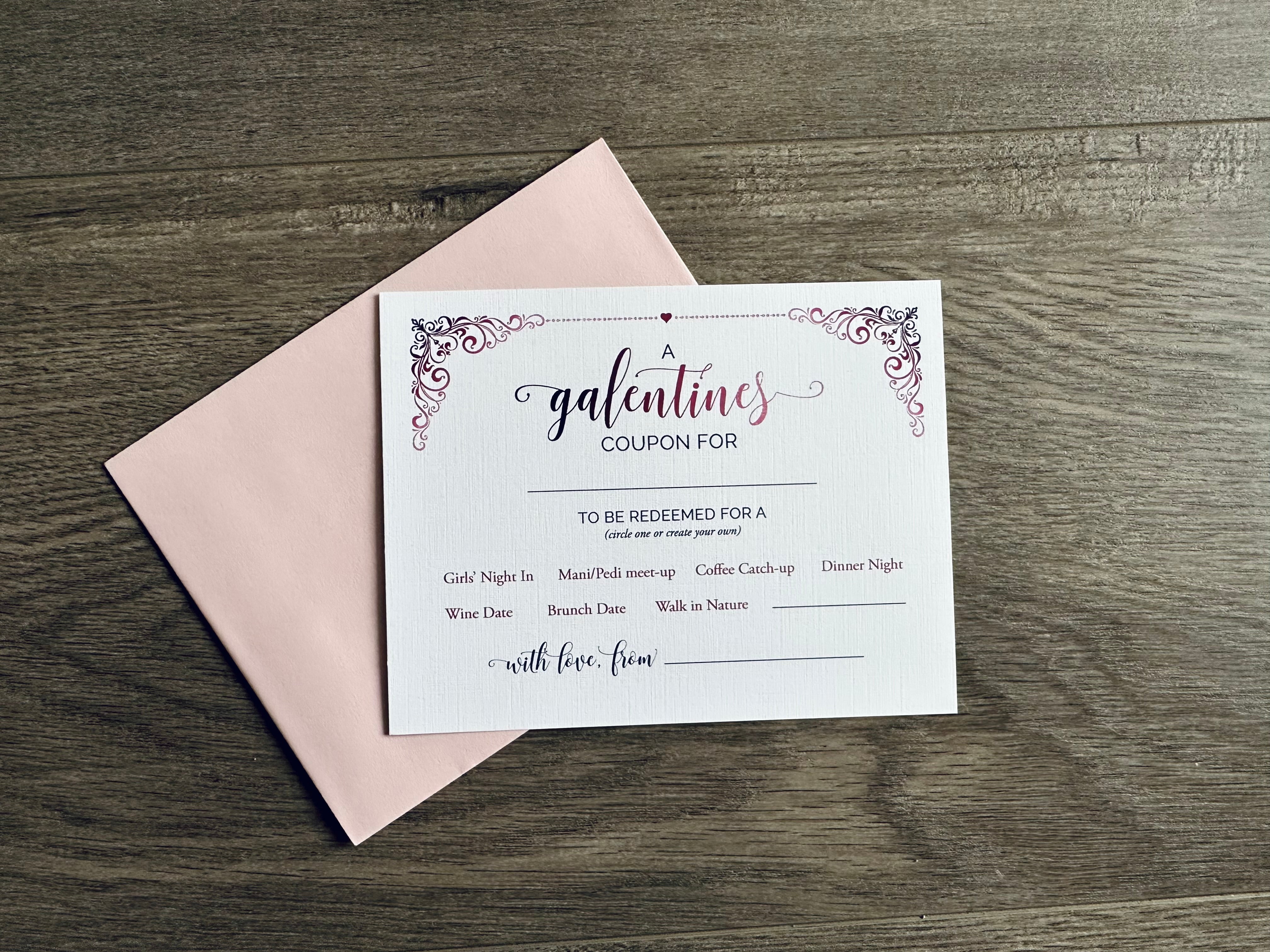 A white card and pale pink envelope lie flat on a wooden floor. The card is a "galentines coupon" with friend catch-up inspired ideas written as suggestions to do at a later date. By Stationare