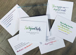 Six white notecards are overlapped on a wooden background. Each card has a friendship-inspired thank you sentiment on the front. Thanks Friend Collection by Stationare.