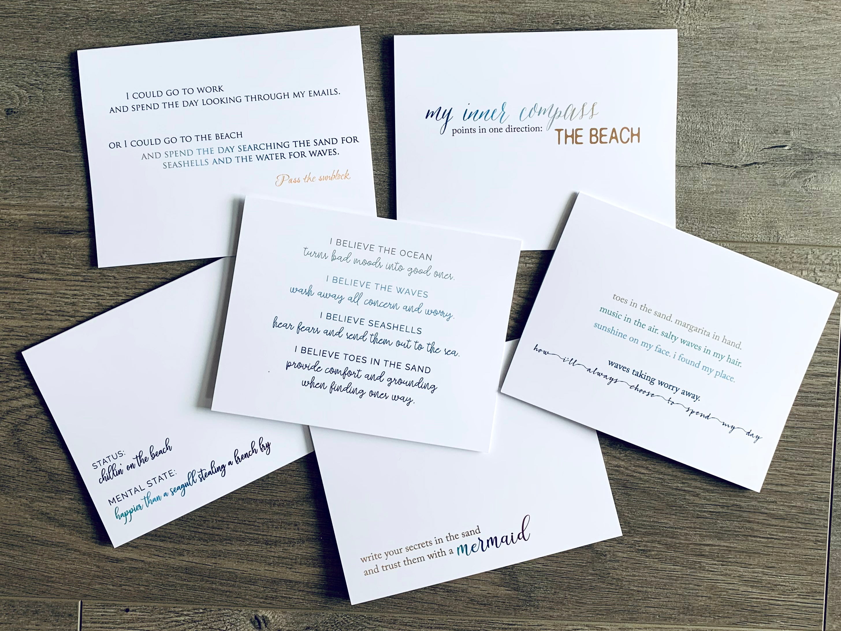 Six white notecards lie on a wooden background. Each card hosts a comical saying about enjoying life at the beach.