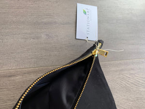closeup of gold zipper and black interior of black makeup bag