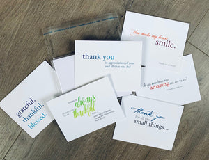 Six white thank you notes are compiled on a wooden background. The Expressing Gratitude collection by Stationare.