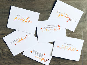 A collage of six fall-themed white notecards are overlapped on a wooden background. The I Love Fall Collection by Stationare.