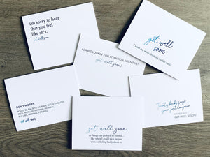 Six white notecards are overlapped on a gray wood background. Each card has a humorous saying that wishes the recipient get well soon. Joyful Well Wishes collection by Stationare.