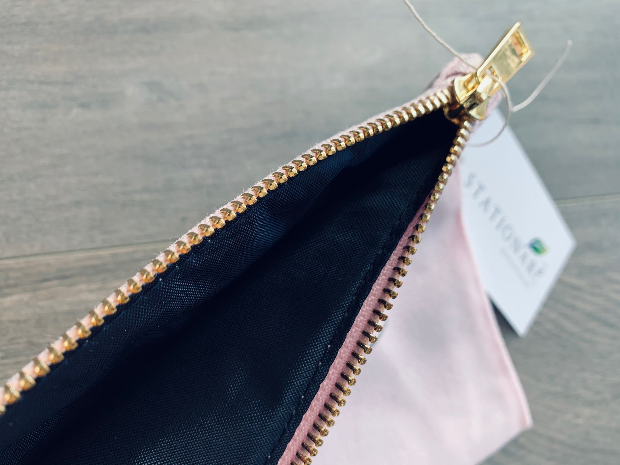 closeup of gold zipper and interior of pink makeup bag