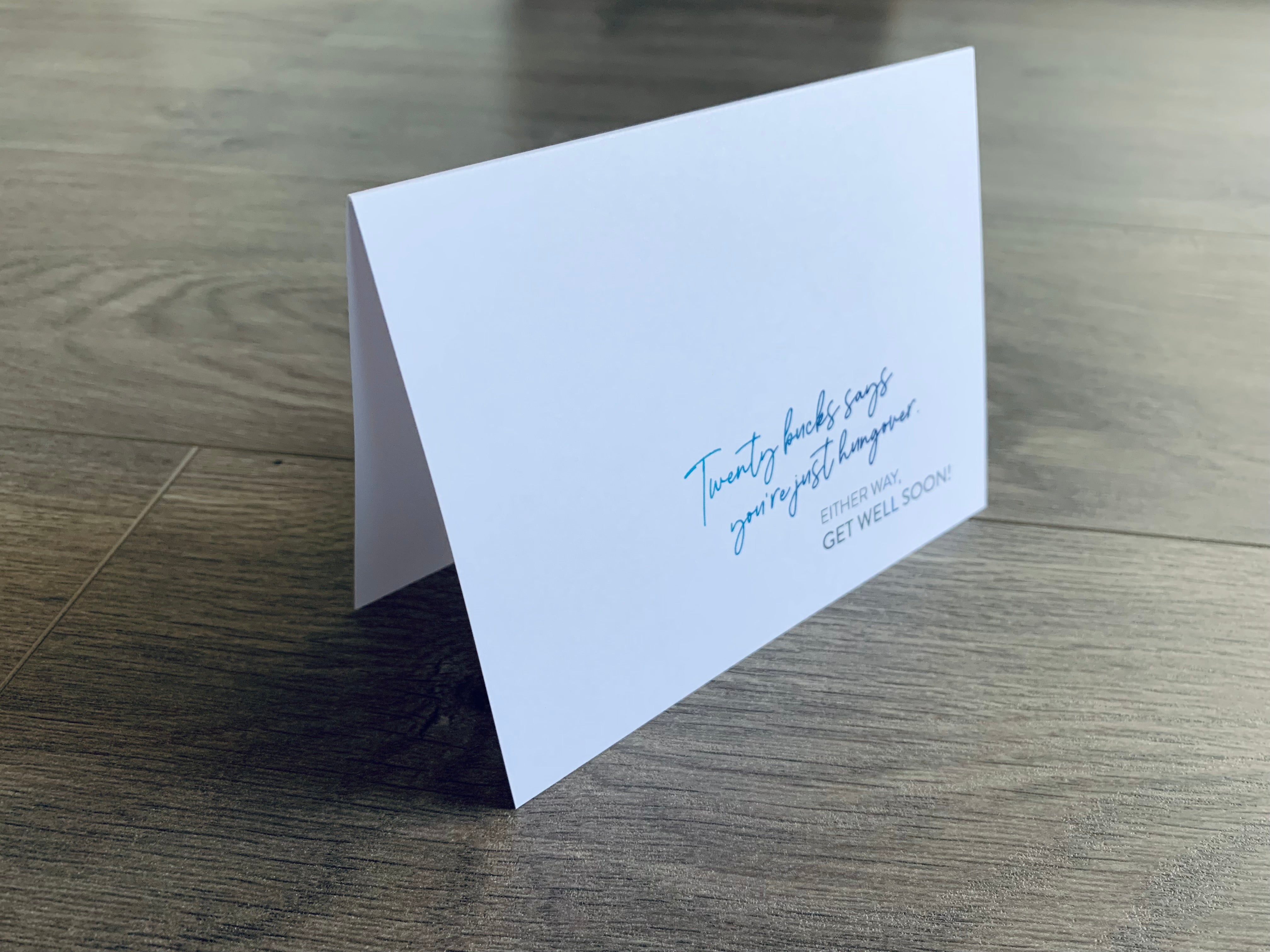 A white notecard that reads, "Twenty bucks says you're just hungover. Either way. get well soon." Joyful Well Wishes collection by Stationare.
