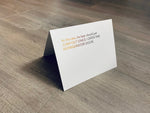 A white card is propped on a gray wood floor. The card reads, "At the rate, the beer should just jump out once I open the refrigerator door." Beer Lovers Collection by Stationare.