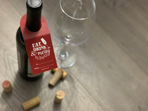 eat drink and be merry gift tag staged with wine glass and corks image by stationare