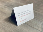 A folded white notecard is folded and propped up on a gray wooden background. The card says, "You are the finest, loveliest, tenderest, and most beautiful person I have ever known and even that is an understatement. Happy Valentine's Day." Historic Love collection by Stationare.