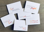 Collection of six love-themed notecards lie on a wooden background. Love Collection by Stationare.