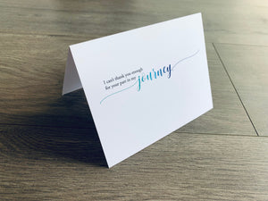 A white, folded notecard sits on a wooden floor. The card says, "I can't thank you enough for your part in my journey." The Friendship collection by Stationare.