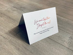 A folded white notecard is folded and propped up on a gray wooden background. The card says, "We were together. I forget the rest. May we have many more fun adventures ahead! Happy Valentine's Day!" Historic Love collection by Stationare.