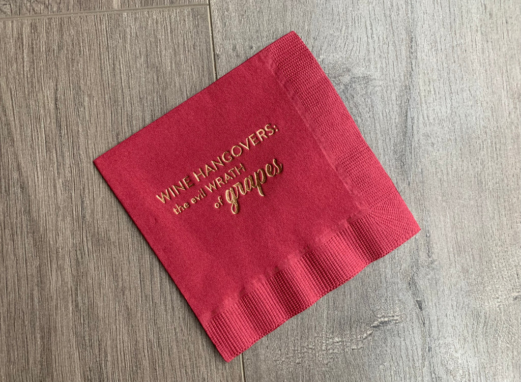 Burgundy cocktail napkin with gold metallic foil that reads "wine hangovers: the evil wrath of grapes" wine night appetizer napkin